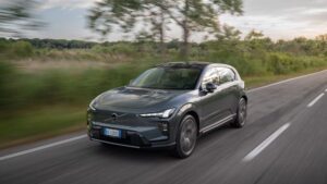 Volvo EX60 grigia in movimento su una strada extraurbana