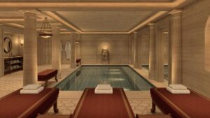 Rendering di una piscina interna con lettini nel progetto alberghiero romano